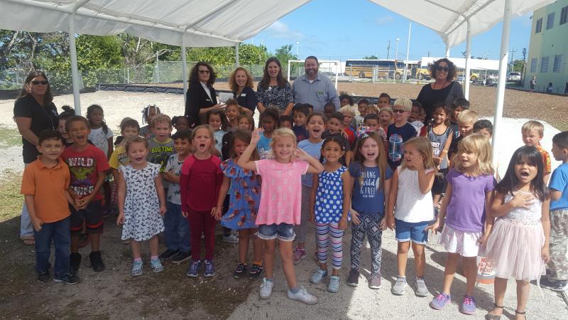Publix managers and UWFK CEO present the Tools for Back to School gift cards while these Stanley Switlik Elementary students voice their thanks.